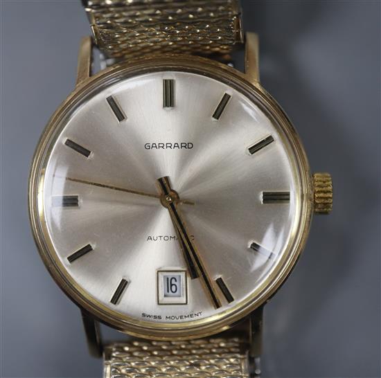 A gentlemans yellow metal automatic wrist watch retailed by Garrard, on associated flexible bracelet.